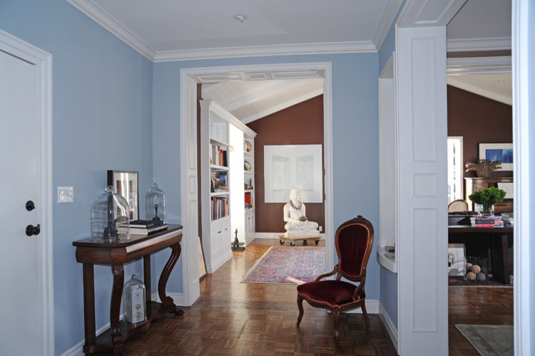 Small elegant medium tone wood floor and brown floor entryway photo in Los Angeles with blue walls and a white front door