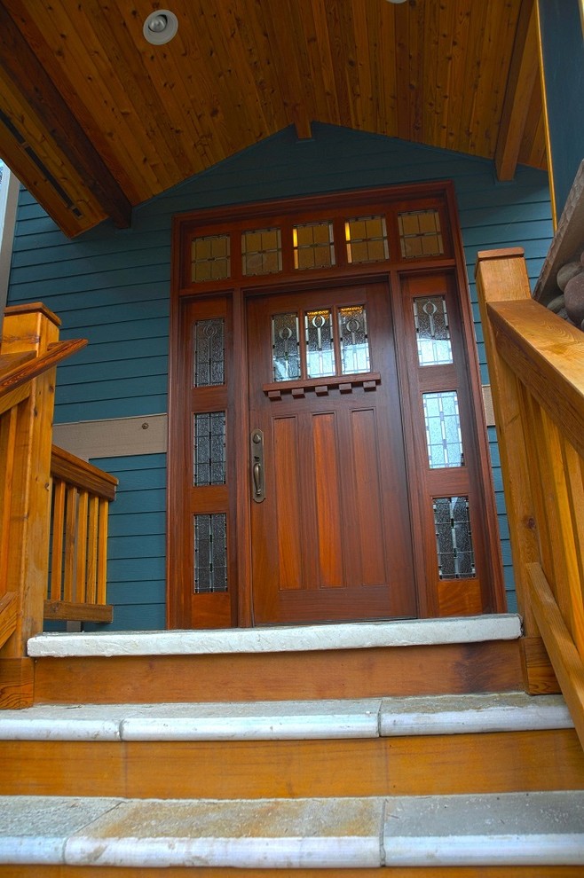 Cette image montre une entrée craftsman avec une porte simple et une porte en bois foncé.