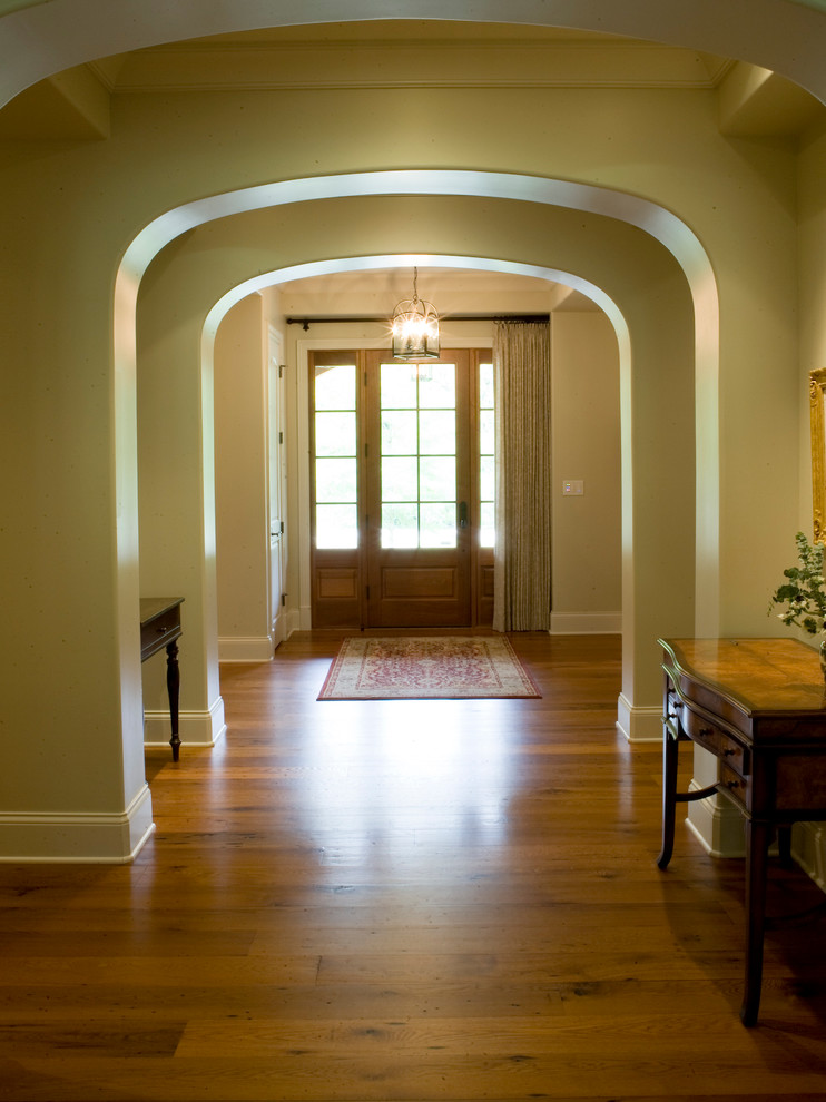 Ispirazione per un ingresso o corridoio classico con pavimento in legno massello medio, una porta singola e una porta in legno bruno
