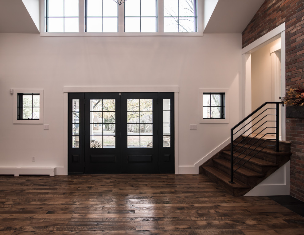 Diseño de distribuidor minimalista extra grande con paredes blancas, suelo de madera oscura, puerta doble, puerta negra y suelo marrón
