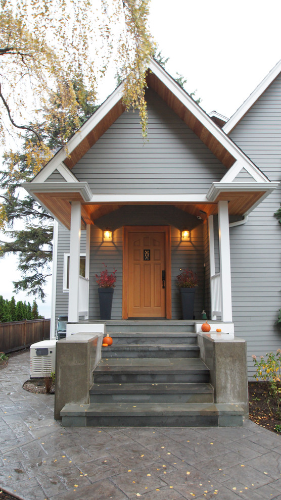 シアトルにある中くらいなトラディショナルスタイルのおしゃれな玄関ドア (淡色木目調のドア、グレーの壁、コンクリートの床) の写真