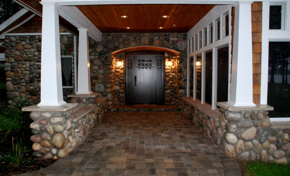 Modelo de puerta principal rústica con paredes grises, suelo de cemento, puerta simple y puerta de madera oscura