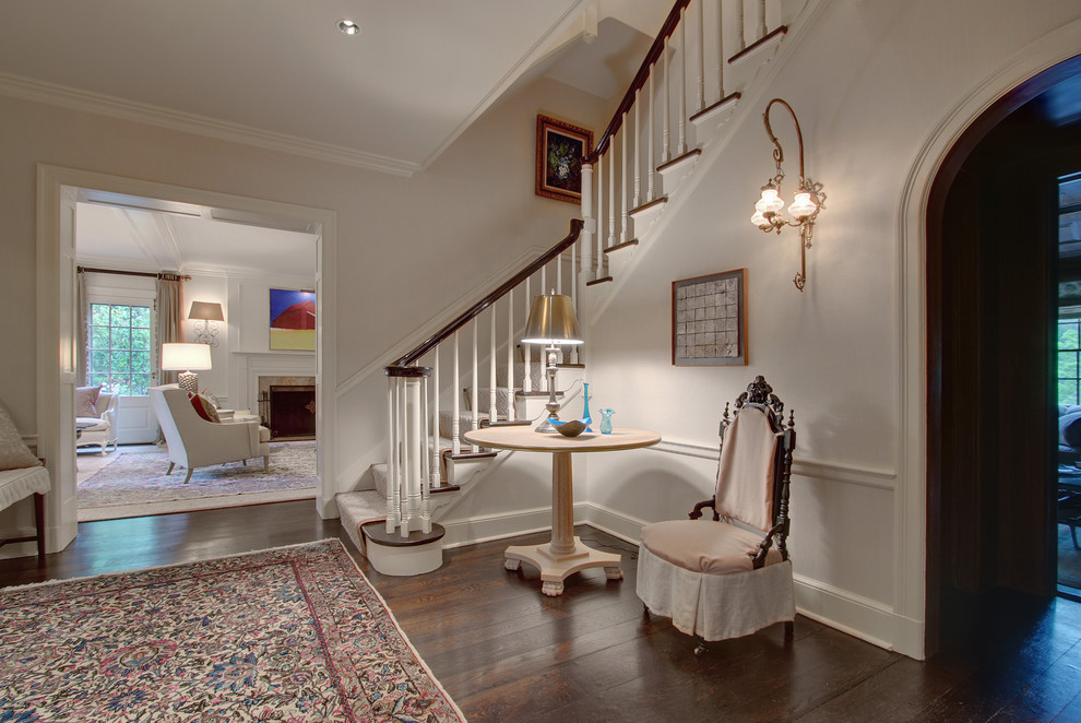 Exemple d'un hall d'entrée chic de taille moyenne avec un mur blanc et parquet foncé.