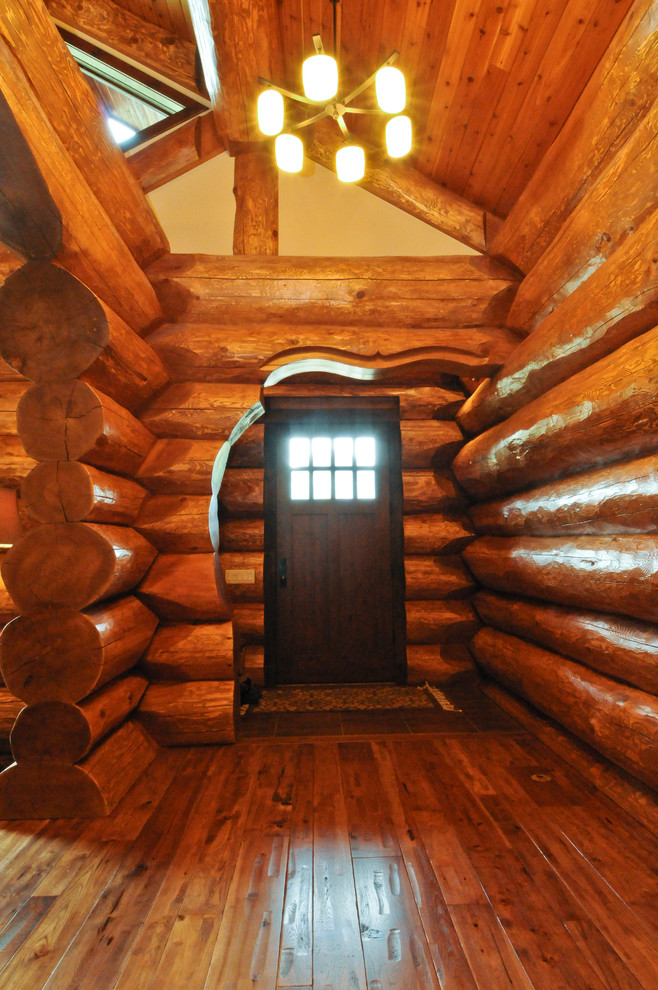 Imagen de distribuidor rústico de tamaño medio con suelo de madera clara, puerta simple, puerta de madera oscura y suelo marrón