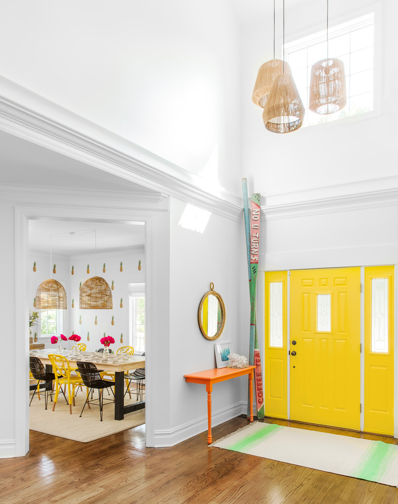 Modelo de distribuidor actual grande con paredes blancas, suelo de madera en tonos medios, puerta simple y puerta amarilla