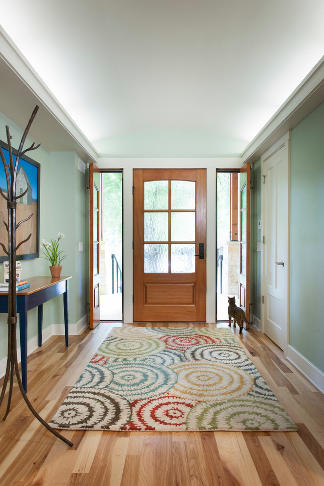 Réalisation d'un hall d'entrée craftsman de taille moyenne avec un mur vert, un sol en bois brun, une porte simple et une porte en bois brun.