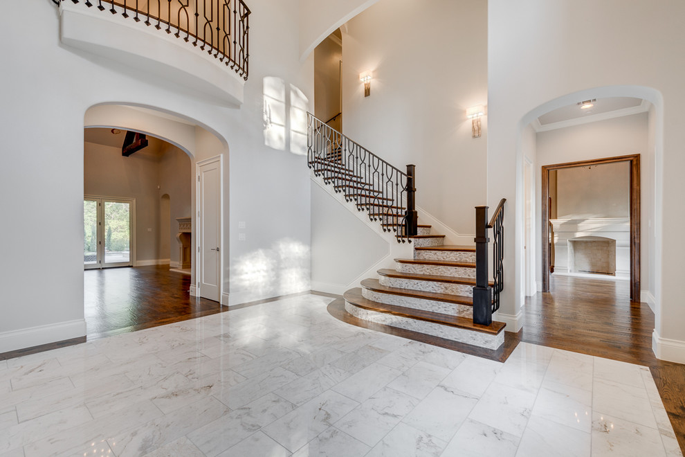 Example of a large transitional marble floor foyer design in Dallas with white walls
