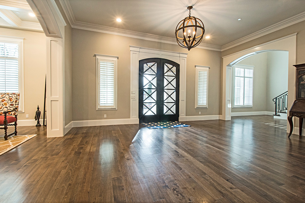 Geräumiges Klassisches Foyer mit grauer Wandfarbe, braunem Holzboden, Doppeltür und schwarzer Haustür in Dallas