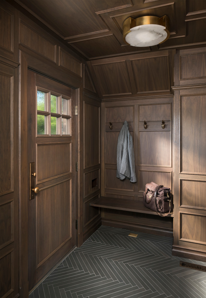 На фото: тамбур в классическом стиле с коричневыми стенами, одностворчатой входной дверью, входной дверью из темного дерева и серым полом с