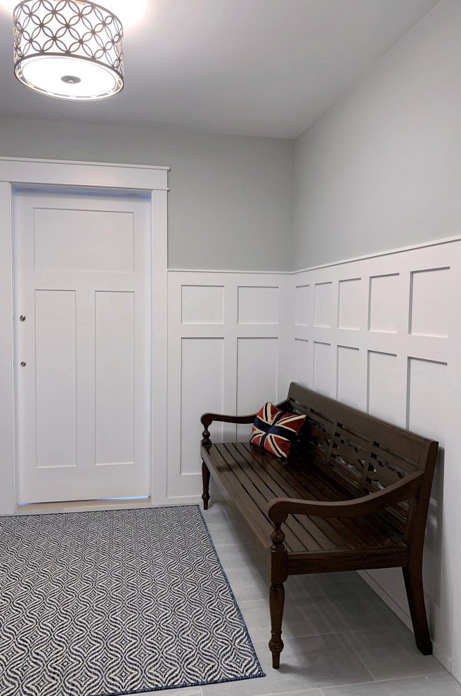 Mittelgroßer Klassischer Eingang mit Stauraum, grauer Wandfarbe, Keramikboden, Einzeltür, weißer Haustür, blauem Boden und vertäfelten Wänden in Sonstige