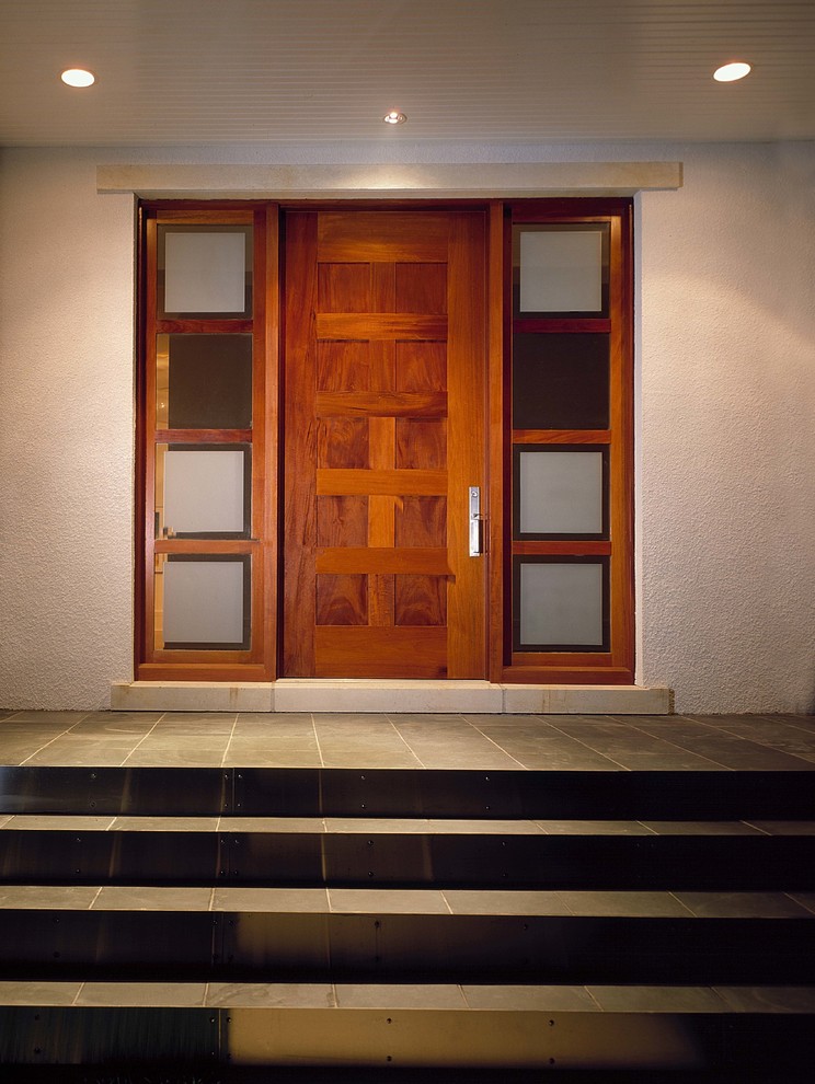 Foto de puerta principal contemporánea de tamaño medio con paredes blancas, puerta simple, suelo de pizarra y puerta de madera en tonos medios