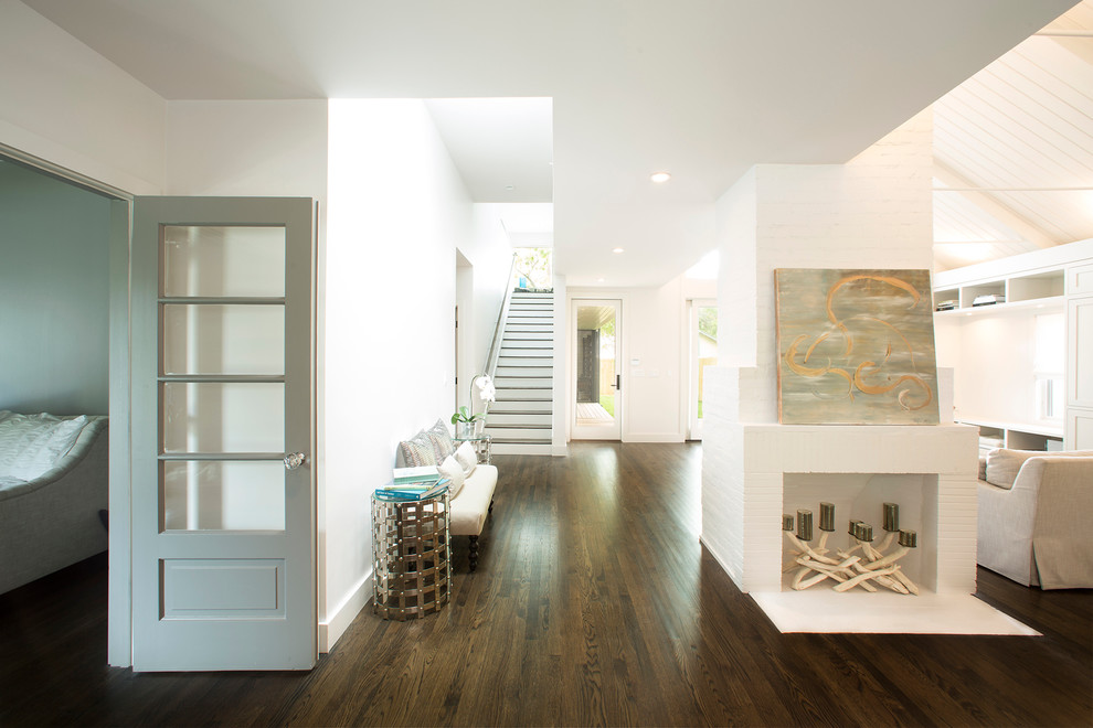 Exemple d'une grande entrée chic avec un mur blanc, parquet foncé, un couloir et un sol marron.