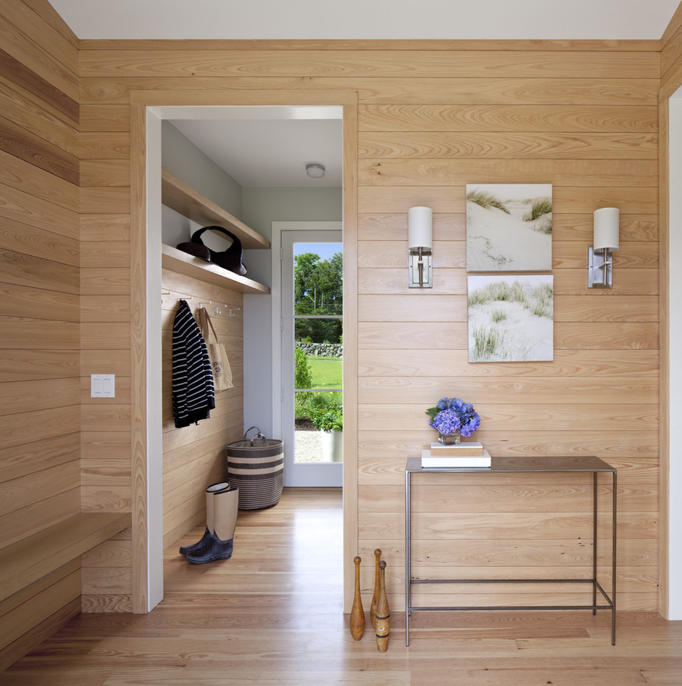 Cette image montre une entrée design avec un sol en bois brun et un vestiaire.