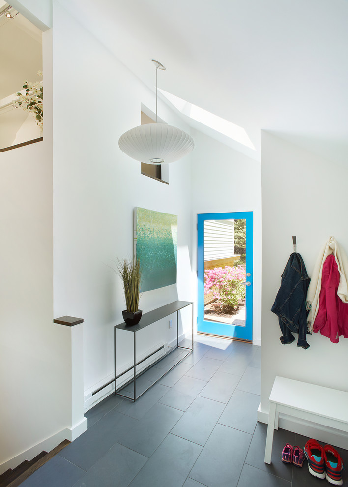 Idee per un ingresso minimal di medie dimensioni con pareti bianche, pavimento in gres porcellanato, una porta singola e una porta blu