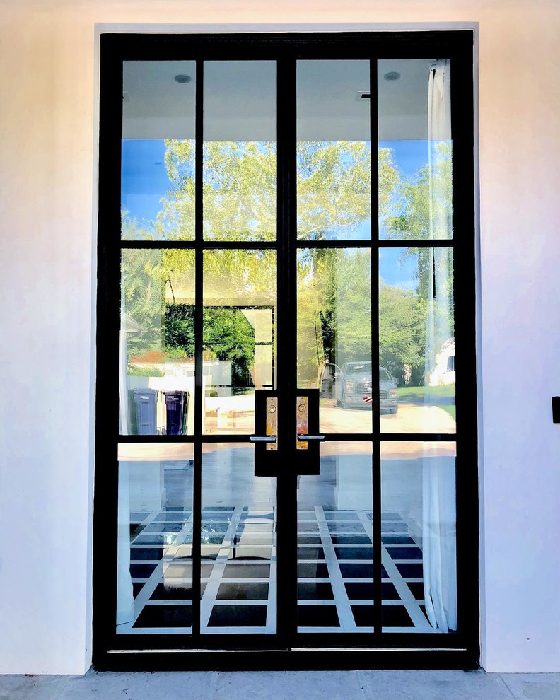 Imagen de puerta principal moderna grande con paredes blancas, suelo de baldosas de porcelana, puerta doble, puerta negra y suelo multicolor