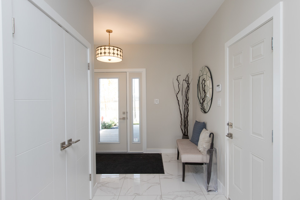 Aménagement d'une petite porte d'entrée classique avec un mur beige, un sol en marbre, une porte simple, une porte blanche et un sol blanc.