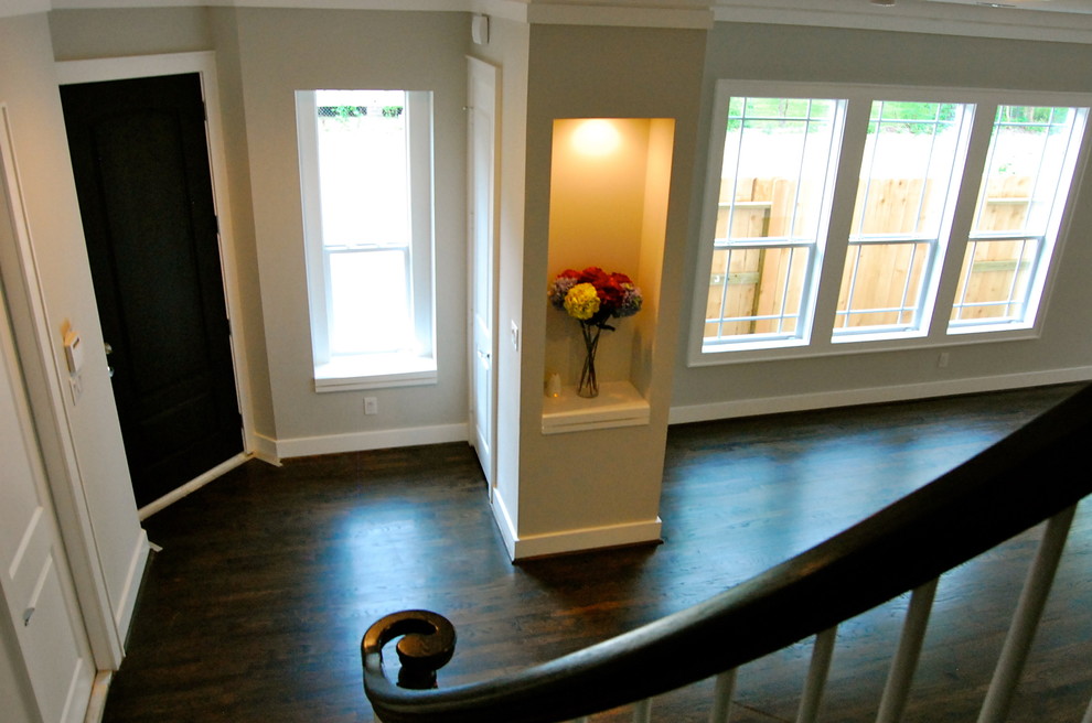 Kleines Modernes Foyer mit grauer Wandfarbe, dunklem Holzboden, Einzeltür und schwarzer Haustür in Houston