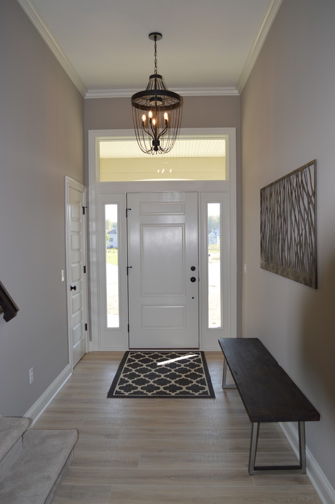 Foto de distribuidor clásico renovado de tamaño medio con paredes beige, suelo vinílico, puerta simple, puerta blanca y suelo beige