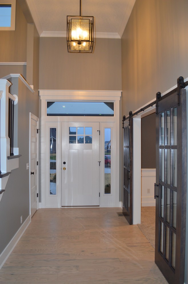 Стильный дизайн: фойе среднего размера в стиле кантри с серыми стенами, светлым паркетным полом, одностворчатой входной дверью и белой входной дверью - последний тренд