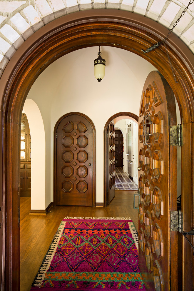 Medelhavsstil inredning av en entré, med beige väggar och mörkt trägolv