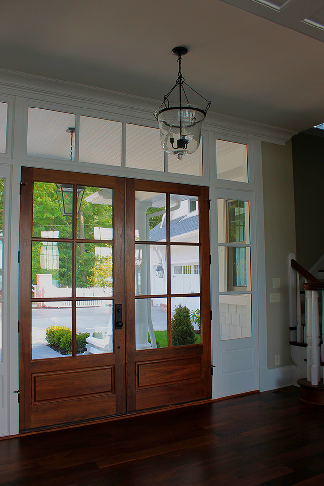 Пример оригинального дизайна: входная дверь в морском стиле с темным паркетным полом, двустворчатой входной дверью и входной дверью из дерева среднего тона