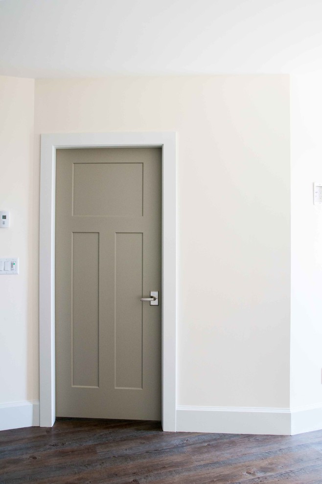 Foto de entrada marinera con paredes blancas, suelo de madera oscura y puerta simple