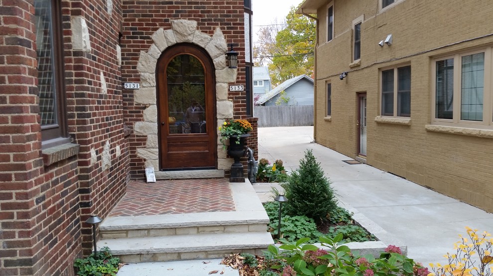 Idée de décoration pour une porte d'entrée tradition de taille moyenne avec un sol en brique.