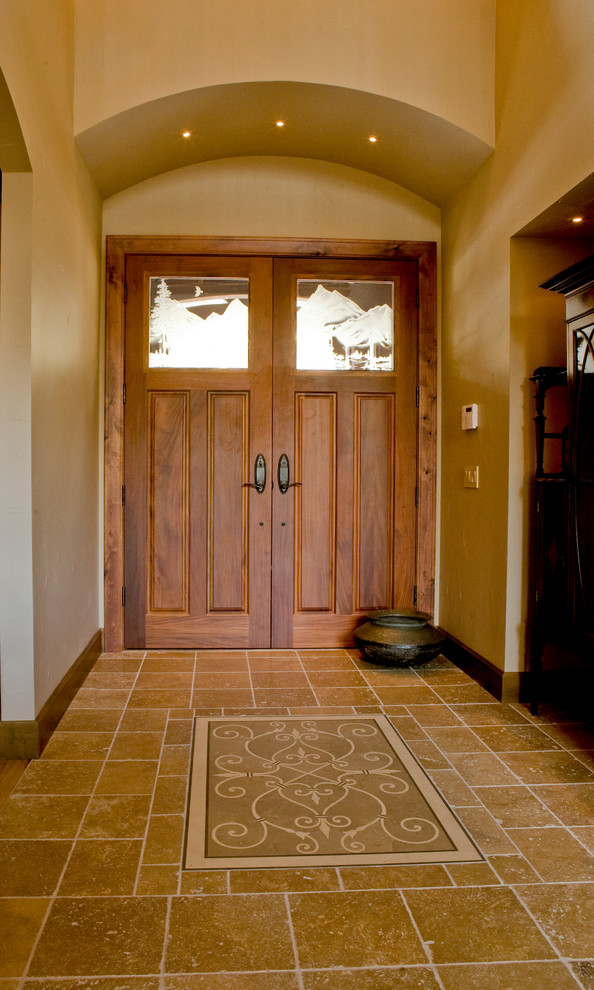 Idée de décoration pour une grande porte d'entrée craftsman avec un mur marron, un sol en travertin, une porte double, une porte en bois brun et un sol marron.