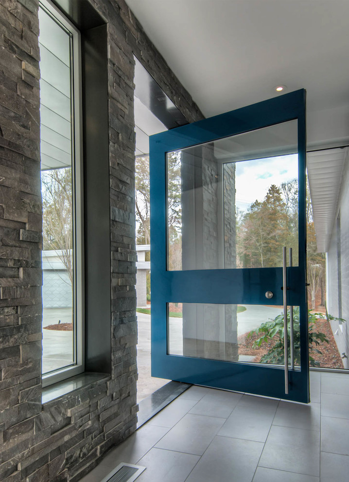 Photo of a medium sized modern foyer in Charlotte with white walls, ceramic flooring, a pivot front door, a metal front door and grey floors.