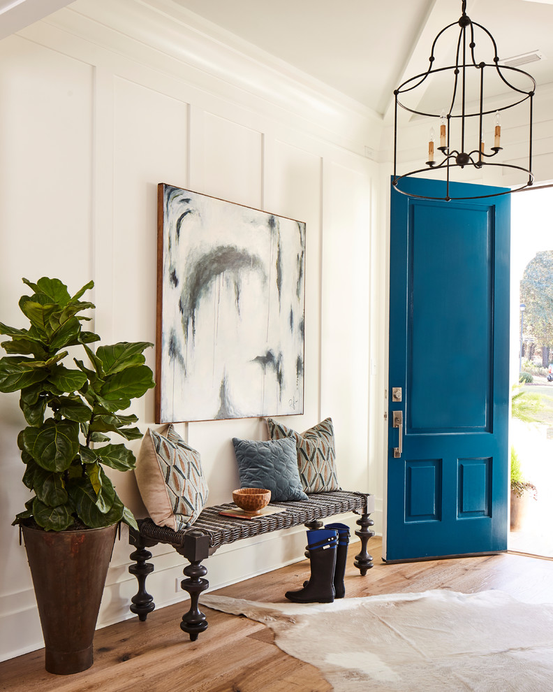 На фото: узкая прихожая в стиле кантри с белыми стенами, паркетным полом среднего тона, синей входной дверью и коричневым полом с
