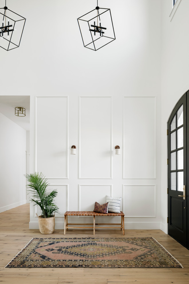 Design ideas for a large classic foyer in Phoenix with white walls, light hardwood flooring, a double front door, a black front door, beige floors and feature lighting.