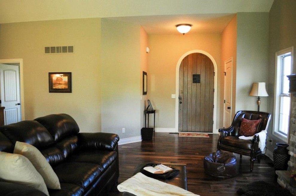 Example of a mid-sized mountain style dark wood floor entryway design in Kansas City with beige walls and a medium wood front door