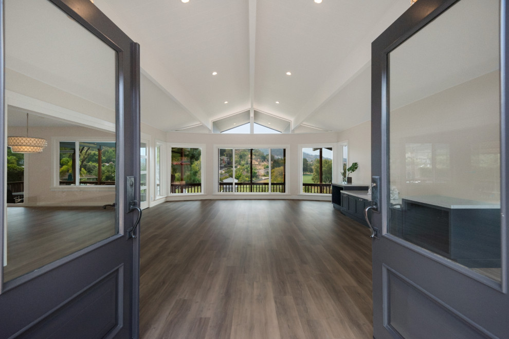 Photo of a large modern front door in San Francisco with grey walls, laminate floors, a double front door, a blue front door, grey floors and a vaulted ceiling.