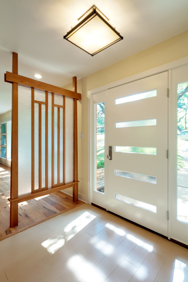 На фото: фойе среднего размера в стиле неоклассика (современная классика) с белыми стенами, полом из керамогранита, одностворчатой входной дверью, белой входной дверью и бежевым полом с