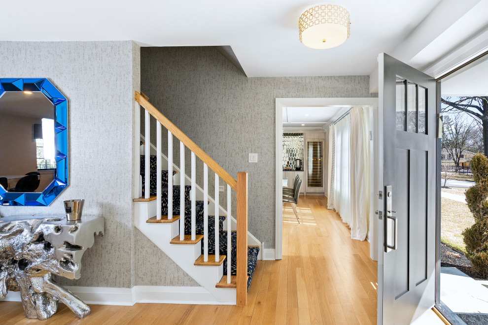 Mittelgroße Moderne Haustür mit weißer Wandfarbe, braunem Holzboden, Einzeltür, braunem Boden, schwarzer Haustür, Tapetenwänden und Treppe