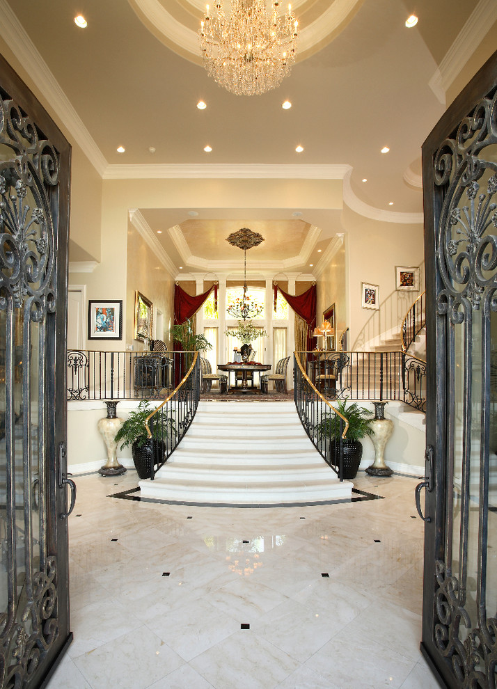 Ispirazione per un ampio ingresso chic con pareti beige, pavimento in marmo, una porta a due ante, una porta in metallo e pavimento beige