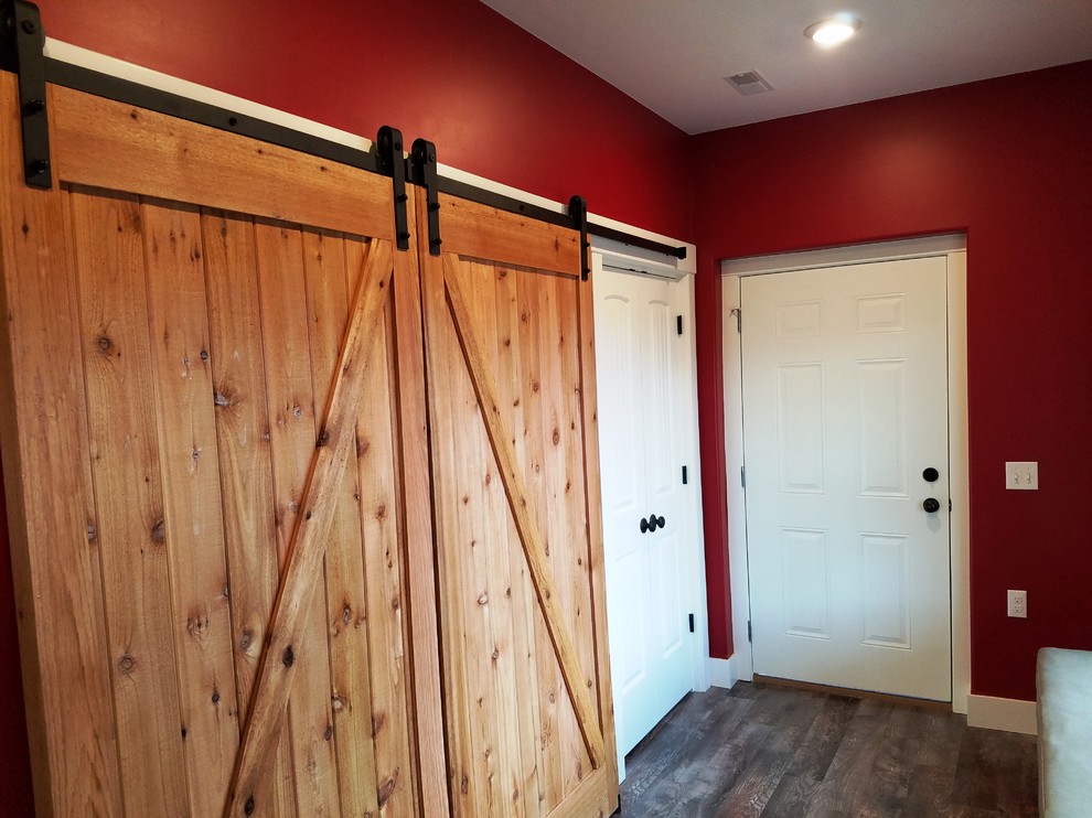 Inspiration pour une petite entrée traditionnelle avec un vestiaire, un mur rouge, un sol en vinyl, une porte simple, une porte blanche et un sol marron.