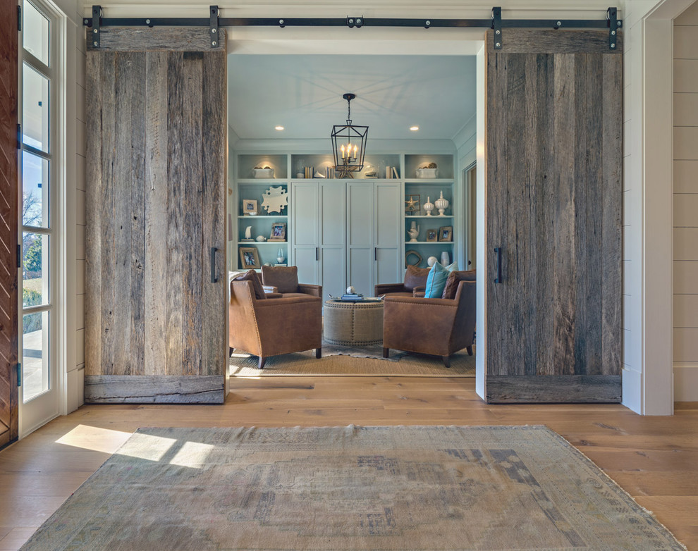 Immagine di un grande ingresso country con pareti bianche, pavimento in legno massello medio, una porta in legno bruno e una porta a due ante
