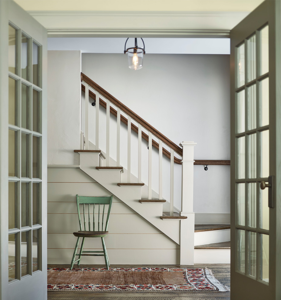 Country Eingang mit weißer Wandfarbe, dunklem Holzboden, Doppeltür, braunem Boden und vertäfelten Wänden in Boston