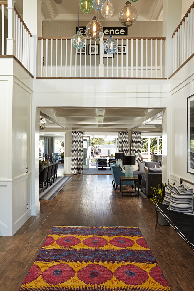 Expansive traditional foyer in Orange County with white walls, light hardwood flooring and a black front door.