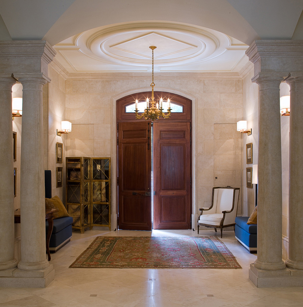 Cette image montre un hall d'entrée traditionnel de taille moyenne avec une porte double, une porte en bois brun, un mur beige et un sol en calcaire.