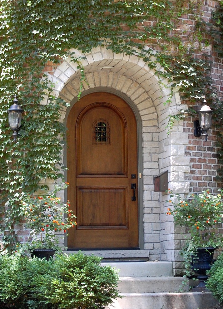 На фото: входная дверь среднего размера в классическом стиле с одностворчатой входной дверью и входной дверью из дерева среднего тона