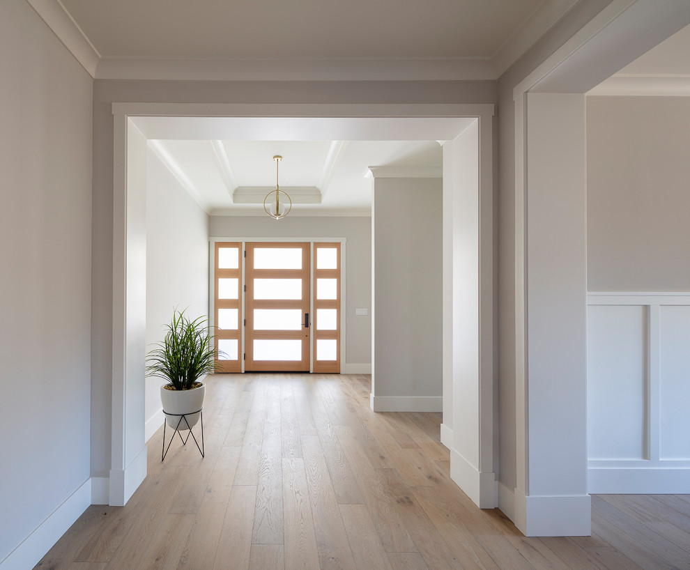 Inspiration pour un grand hall d'entrée rustique avec un mur gris, parquet clair, une porte simple, une porte en bois brun et un sol gris.