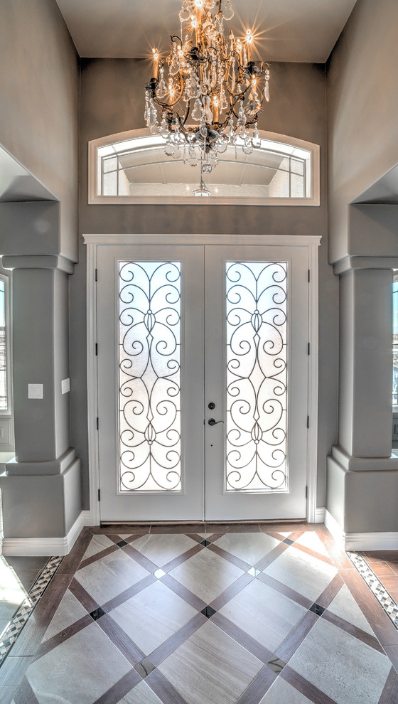 オースティンにある小さなヴィクトリアン調のおしゃれな玄関ドア (グレーの壁、濃色無垢フローリング、白いドア) の写真
