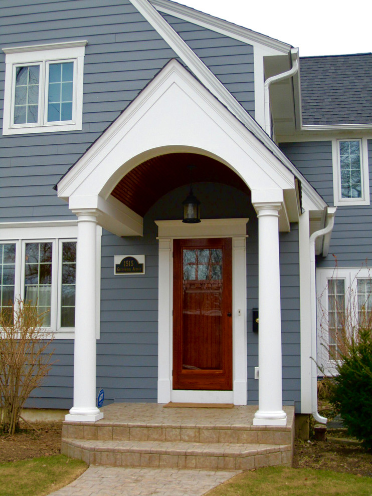 Foto di una porta d'ingresso classica di medie dimensioni con una porta singola, una porta marrone, pavimento in cemento e pavimento beige