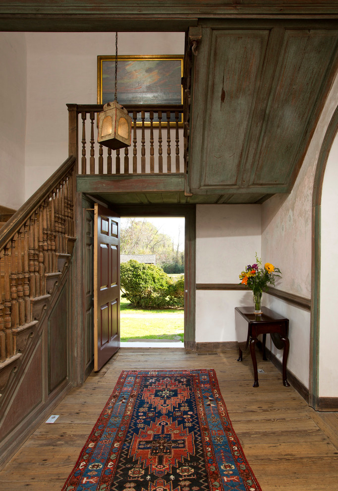 Diseño de hall clásico con paredes beige, suelo de madera en tonos medios, puerta simple y puerta de madera oscura