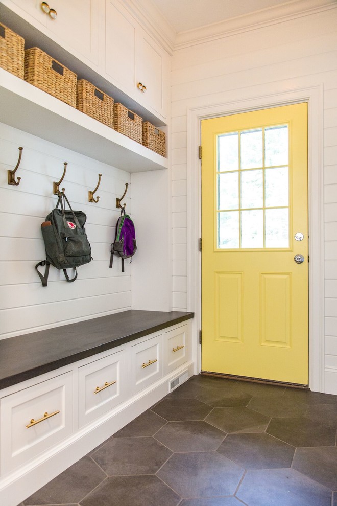На фото: тамбур в стиле неоклассика (современная классика) с белыми стенами, одностворчатой входной дверью, желтой входной дверью и серым полом с