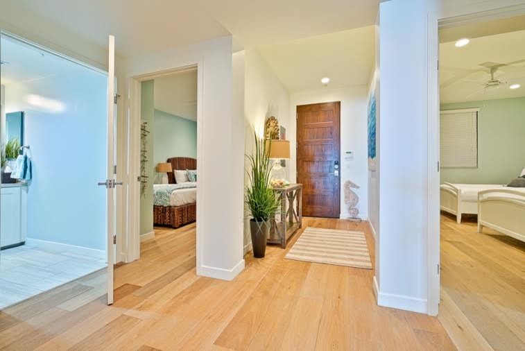 Réalisation d'un petit hall d'entrée marin avec un mur beige, parquet clair, une porte simple et une porte en bois brun.