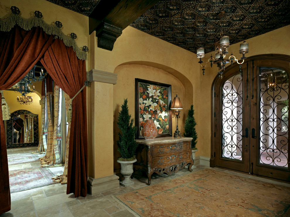 Inredning av en medelhavsstil stor foajé, med gula väggar, travertin golv, en dubbeldörr och mörk trädörr