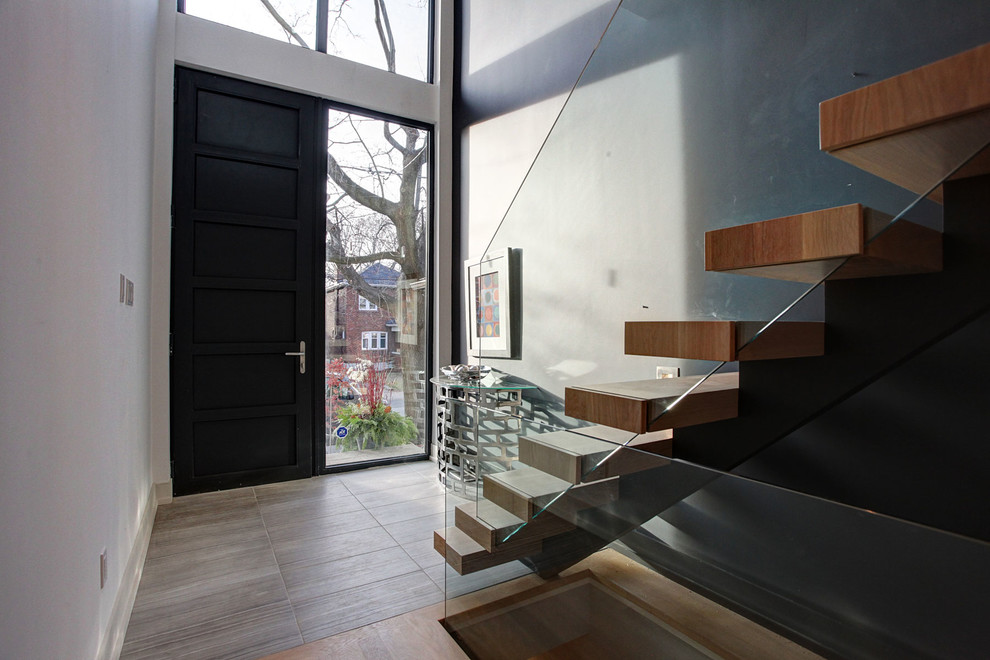 Modern inredning av en mellanstor ingång och ytterdörr, med flerfärgade väggar, klinkergolv i porslin, en enkeldörr, en svart dörr och beiget golv